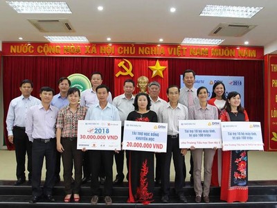 Ông Nguyễn Hồng, Phó tổng biên tập Báo Đầu tư cùng lãnh đạo Công ty DRH Holdings trao biển tượng trưng 50 suất học bổng và 2 phòng máy tính phục vụ học tập cho huyện Hàm Tân nhân dịp năm học mới.