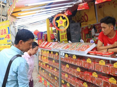 Bảng giảm giá 'mua 1 thành 4' để chung cho nhiều thương hiệu nhưng chỉ áp dụng cho bánh Đồng Khánh khiến nhiều người mua hiểu lầm. Trong ảnh: Khách tìm mua bánh tại cửa hàng ở Q.5. Ảnh: NGUYỆT NHI.