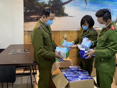 Đội Quản lý thị trường số 15 phối hợp với công an quận Hoàng Mai kiểm tra khẩu trang thu giữ. (Ảnh: Đức Duy/Vietnam+)