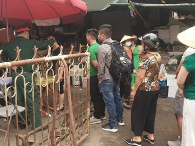 Một tổ công tác đặt tại một trong những lối vào chợ Hạ Long I đang tiến hành đo thân nhiệt ngườii vào chợ trong sáng 27/3.