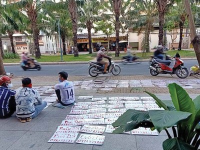 Nhân viên môi giới Công ty Asian Holding viết các bảng rao bán đất để đi treo ở nhiều khu vực với kỳ vọng tìm được khách mua. Ảnh: Gia Huy