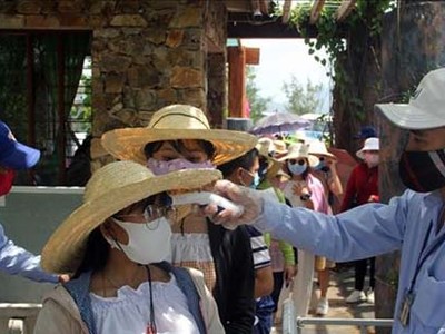 Đo thân nhiệt cho du khác. Ảnh: Xuân Triệu