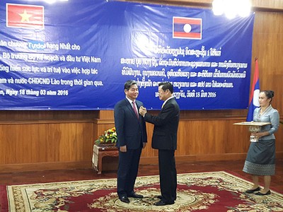 Thừa ủy quyền của Chủ tịch nước CHDCND Lào, Phó Thủ tướng Chính phủ Lào Xomxavat Lengxavath trao tặng cho Bộ trưởng Bùi Quang Vinh Huân chương Isala hạng Nhất
