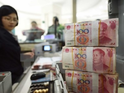 Nhân viên kiểm đồng nhân dân tệ tại một ngân hàng ở tỉnh Giang Tô. (Nguồn: AFP/TTXVN)