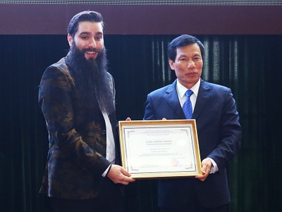 Bộ trưởng Văn hóa Thể thao và Du lịch trao giấy chứng nhận Đại sứ Du lịch Việt Nam cho ông Jordan Vogt-Roberts. Ảnh: Giang Huy.