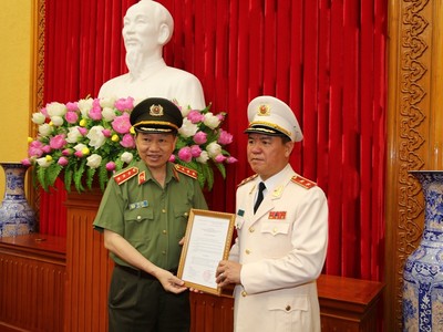 Bộ trưởng Tô Lâm trao quyết định cho Trung tướng Trần Văn Vệ. Ảnh MPS