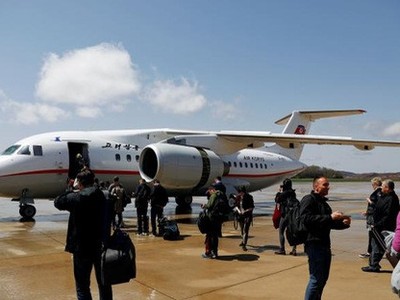 Hành khách chuẩn bị lên một máy bay của Air Koryo ở sân bay Bình Nhưỡng hôm 18/4 - Ảnh: Reuters.