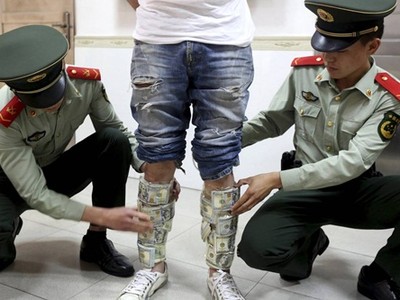 Một người bị bắt vì chuyển tiền lậu từ Trung Quốc sang Hong Kong. Ảnh: Reuters