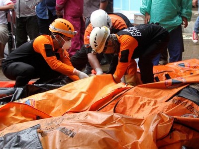 Lực lượng cứu hộ Indonesia bên cạnh túi đựng thi thể nạn nhân sáng 24/12. Ảnh: AFP.