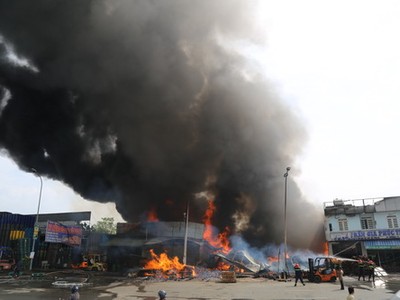 Đám cháy xuất phát từ bãi chứa vật liệu xây dựng bên quốc lộ 1. Ảnh: Phước Tuấn.