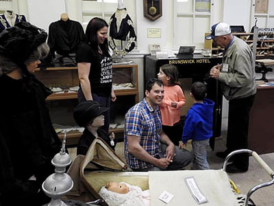 Khoảnh khắc Stephen Mills (áo caro) cùng vợ con vui mừng khi giải được mật mã trong khi tình nguyện viên Tom Kibblewhite (đội mũ) xem đồ đạc bên trong két. Ảnh: CNN.