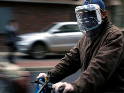 Một người dân đeo khẩu trang và mặt nạ tự chế từ chai nhựa trên đường phố Thượng Hải, Trung Quốc hôm 22/3. Ảnh: Reuters.