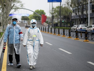 Dân Vũ Hán mặc đồ bảo hộ đi trên phố ngày 31/3. Ảnh: AFP.