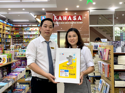 Đại diện nhà sách Fahasa Tân Bình (bên trái) nhận Máy phun gel rửa tay tự động từ đại diện công ty Thiên Long Hoàn Cầu – công ty thành viên của Tập đoàn Thiên Long.