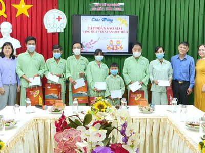 Bà Lê Thị Nguyệt Thu - Chủ tịch HĐQT Tập đoàn Sao Mai (bìa bên phải) tặng quà cho bệnh nhân nghèo tại Bệnh Viện Răng Hàm Mặt An Giang