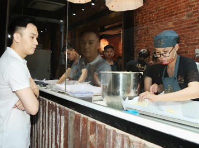 Ca sỹ Dương Triệu Vũ theo dõi đội ngũ thợ làm bánh.