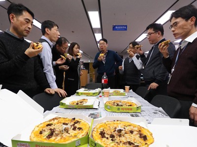 Cán bộ Bộ Chiến lược và Tài chính Hàn Quốc thưởng thức pizza do Tổng thống Moon Jae-in tặng. Ảnh: Yonhap