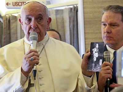 Giáo hoàng Francis cho phóng viên xem ảnh chụp các nạn nhân của bom nguyên tử ở Hiroshima, Nhật Bản, năm 1945 khi trả lời báo giới ngày 15/1. Ảnh: AFP.