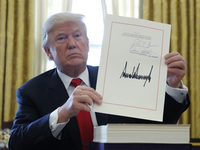 Tổng thống Mỹ Donald Trump cầm bản cải cách thuế với chữ ký của ông tại Phòng Bầu dục, Nhà Trắng, ngày 22/12 (Ảnh: VnEpress/Reuters)