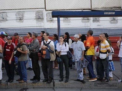 Người dân chờ xe buýt ở Caracas. Ảnh: AP.