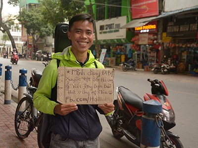 Hồ Nhật Hạ với tấm biển giới thiệu về mình và đề nghị tặng bài hát cho những người bạn mới gặp khi quay trở lại Hà Nội ngày 16/3.