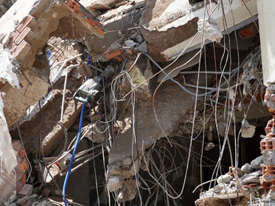 Máy khoan còn cắm vào đống đổ nát. Ảnh: Sơn Hòa.