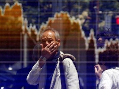 Một người đàn ông nhìn bảng điện tử trên đường phố Tokyo. Ảnh: Reuters.