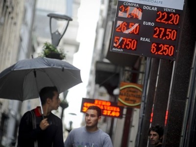 Người dân đi qua một quầy đổi tiền ở thủ đô Buenos Aires. Ảnh: AP.