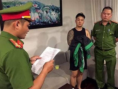 Nhà chức trách đọc lệnh bắt một người trong đường dây đánh bạc. Ảnh: Cơ quan điều tra Bộ Công an.