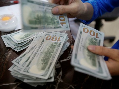 Một nhân viên ngân hàng đếm tiền USD tại Hà Nội. Ảnh: Reuters.