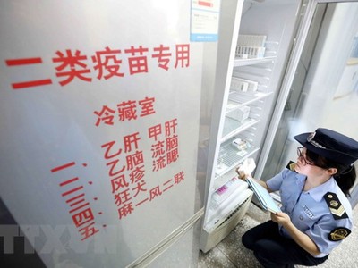 Nhân viên thực thi pháp luật thuộc Cơ quan quản lý và giám sát thị trường kiểm tra việc cung ứng vắc-xin tại Dung An, khu tự trị dân tộc Choang Quảng Tây, Trung Quốc ngày 23/7 vừa qua. (Ảnh: EPA/TTXVN).