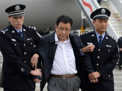 Tội phạm kinh tế Li Huabo bị cảnh sát Trung Quốc dẫn giải về nước sau khi biển thủ hàng triệu USD và ẩn náu nhiều năm ở Singapore. (Ảnh: WSJ).