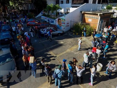 Người dân Venezuela xếp hàng chờ đổi tiền bên ngoài ngân hàng trung ương ở Caracas. (Nguồn: AFP/TTXVN).
