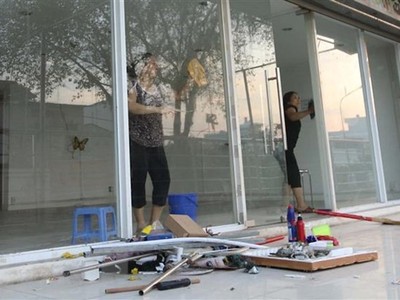 Cư dân block A, chung cư Carina Plaza trở về thu dọn để mở cửa lại quán cà phê Yuki ở tầng 1. (Ảnh: Thanh Vũ/TTXVN).