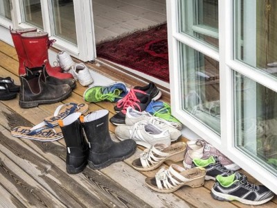 Tháo giày trước khi vào nhà để tránh mang những vi khuẩn gây bệnh vào trong nhà. Ảnh: KP.