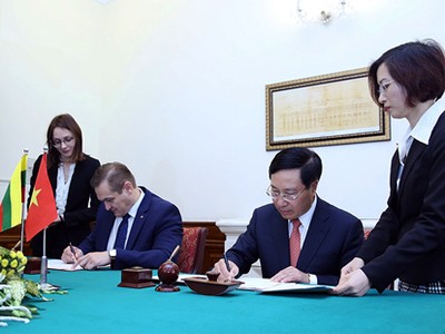 Phó Thủ tướng Phạm Bình Minh và Bộ trưởng Nội vụ Litva Eimutis Misiunas ký Hiệp định miễn thị thực cho người mang hộ chiếu ngoại giao và công vụ giữa hai nước. Ảnh: VGP/Hải Minh.