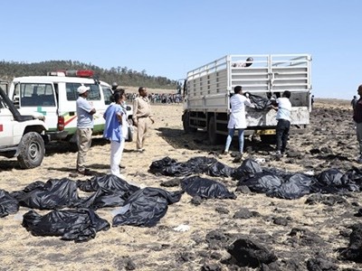 Nhân viên cứu hộ tại hiện trường vụ tai nạn thu thập các thi thể, bọc trong túi nilon và chuyển đi. Ảnh: Reuters.