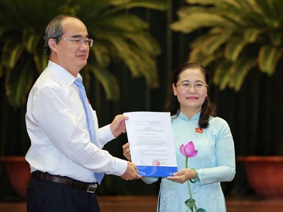 Ủy viên Bộ Chính trị, Bí thư Thành ủy TPHCM Nguyễn Thiện Nhân trao Nghị quyết của UBTVQH cho đồng chí Nguyễn Thị Lệ.