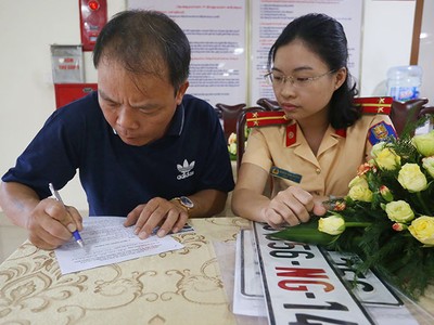 Một tài xế làm thủ tục cấp đổi biển số, sang tên ở Cục Cảnh sát giao thông. Ảnh: Bá Đô.