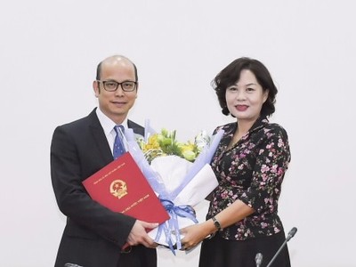 Phó Thống đốc Nguyễn Thị Hồng trao quyết định và chúc mừng đồng chí Bùi Huy Thọ.