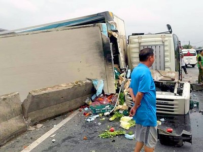 Sau khi tông sập dải phân cách xe tải lật ngang khiến quốc lộ 1 ùn tác cục bộ. Ảnh: B.T.