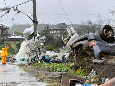 Một công nhân đứng giữa chụp ảnh những mảnh vỡ sau cơn bão Hagibis quét qua Ichihara, Chiba, gần Tokyo. (Nguồn: AP).