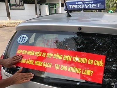 Nhiều hãng taxi truyền thống tại Hà Nội dán khẩu hiệu yêu cầu taxi công nghệ gắn mào. 