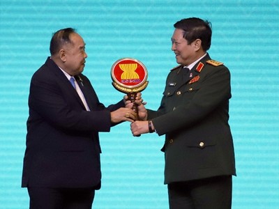 Bộ trưởng Ngô Xuân Lịch nhận biểu trưng cho vai trò Chủ tịch ADMM và ADMM+ từ Đại tướng Prawit Wongsuwan, Phó Thủ tướng Thái Lan. Ảnh QĐND