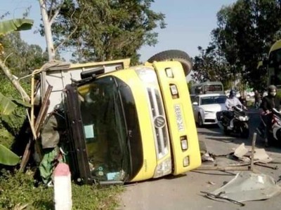 Chiếc xe tải nằm lật nghiêng bên vệ đường.