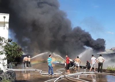 Lực lượng chữa cháy nỗ lực không chế ngọn lửa tại hiện trường. (Ảnh: Nguyễn Văn Việt/TTXVN)