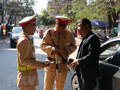 Lực lượng cảnh sát giao thông tỉnh Cà Mau kiểm tra nồng độ cồn của người tham gia giao thông (ảnh chụp đêm 5/1). (Ảnh: Huỳnh Thế Anh/TTXVN)