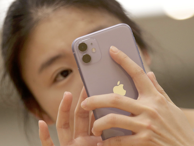 Một người tiêu dùng Trung Quốc sử dụng iPhone 11. (Nguồn: Reuters).
