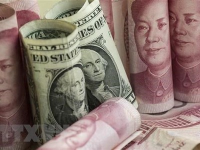 Đồng nhân dân tệ và đồng USD tại một ngân hàng ở Bắc Kinh, Trung Quốc. (Ảnh: AFP/TTXVN).