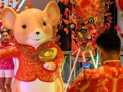 Một phụ nữ chụp ảnh tại cửa hàng trang trí mừng Tết Nguyên đán ở Thái Lan hôm nay. Ảnh: AFP.